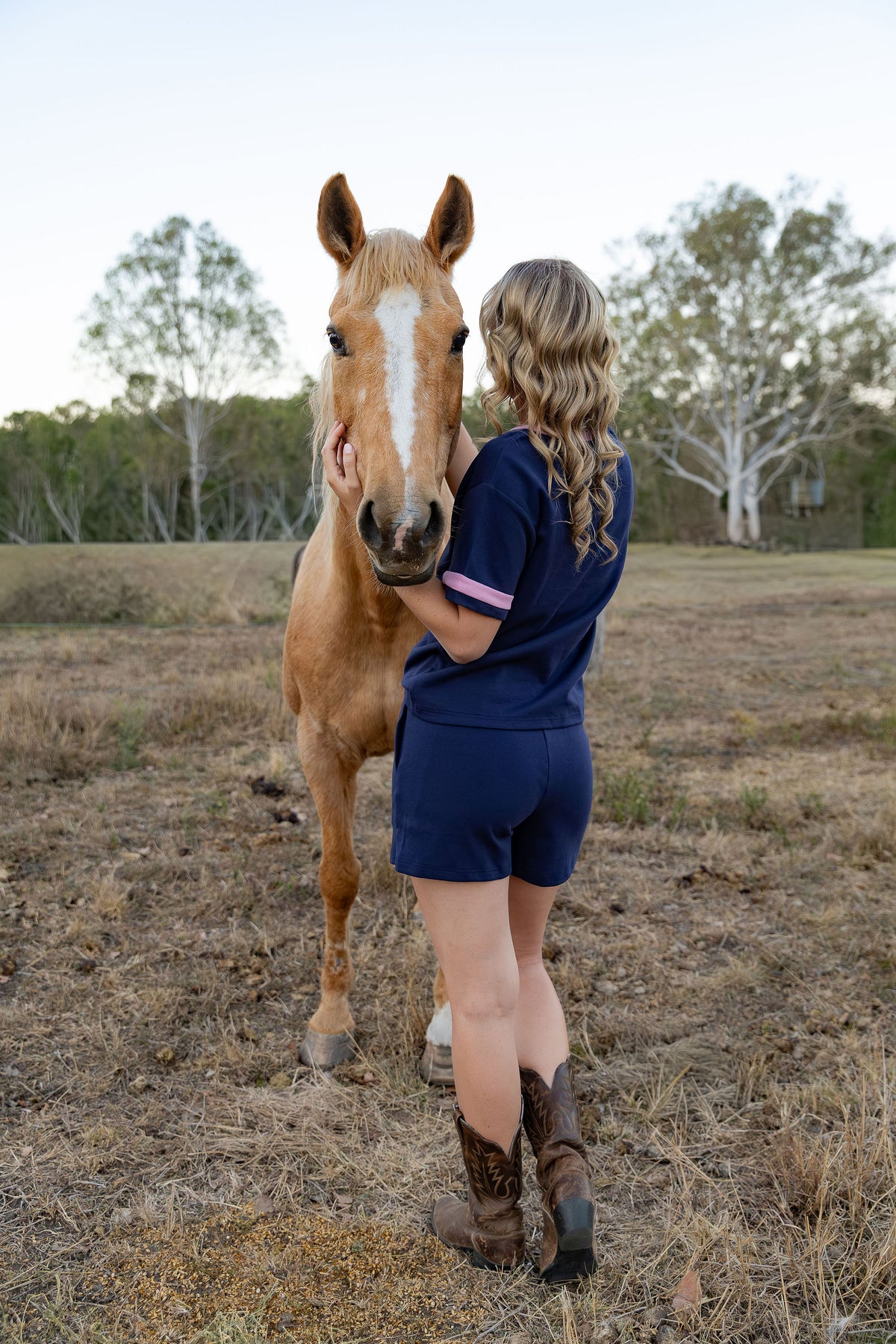 Back view of womens navy and pink loungewear tee and matching navy shorts, Cobba Country country style set worn with cowboy boots